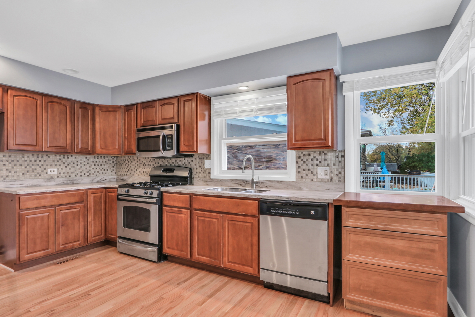 1186 Highland Road Mundelein, IL 60060 - Photo 9 of 28 a kitchen with stainless steel appliances granite countertop wooden cabinets a sink and a stove