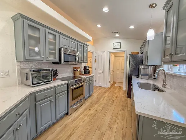 a kitchen with stainless steel appliances granite countertop a sink stove and refrigerator