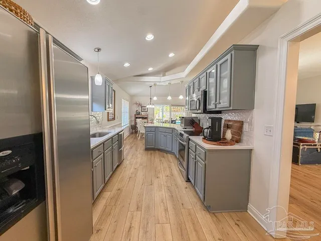 a kitchen with stainless steel appliances granite countertop a refrigerator a stove top oven a sink and dishwasher