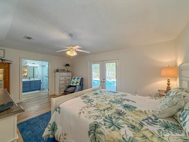 a bedroom with a large bed and a chandelier