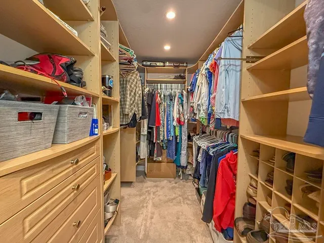 a view of walk in closet with clothes