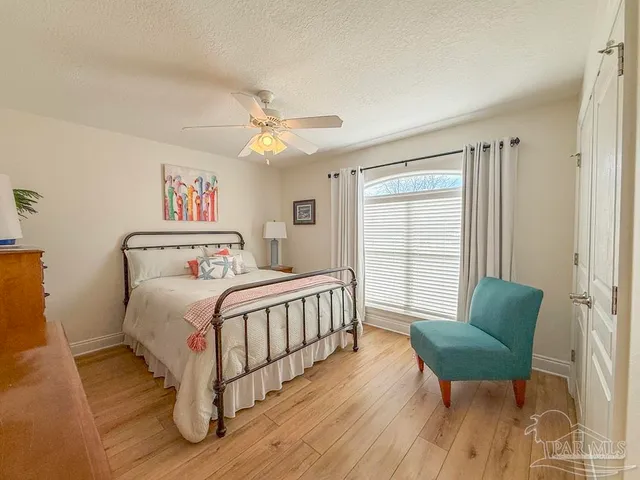 a bedroom with a bed a chandelier and a window