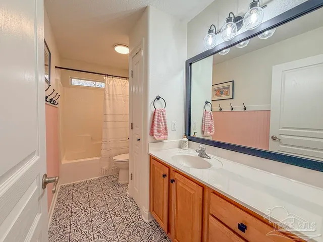 a spacious bathroom with a sink a toilet a shower and a mirror