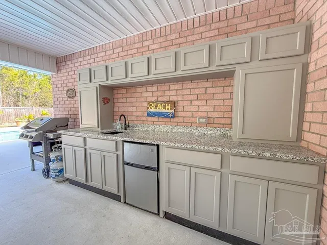 a kitchen with stainless steel appliances granite countertop white cabinets and window