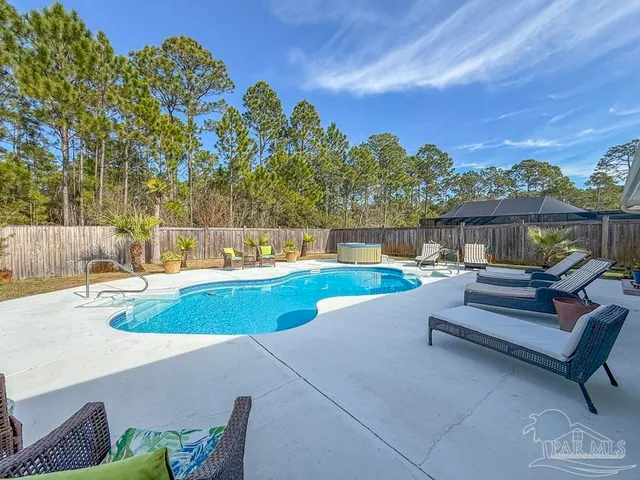 a view of a swimming pool with a patio and a yard