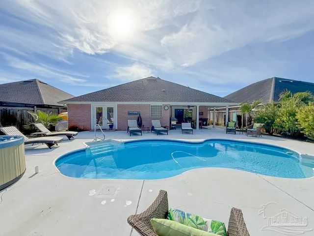 a view of house with swimming pool outdoor seating
