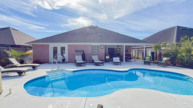 a view of a house with swimming pool and sitting area