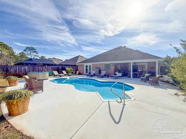 a view of swimming pool with outdoor seating and a garden