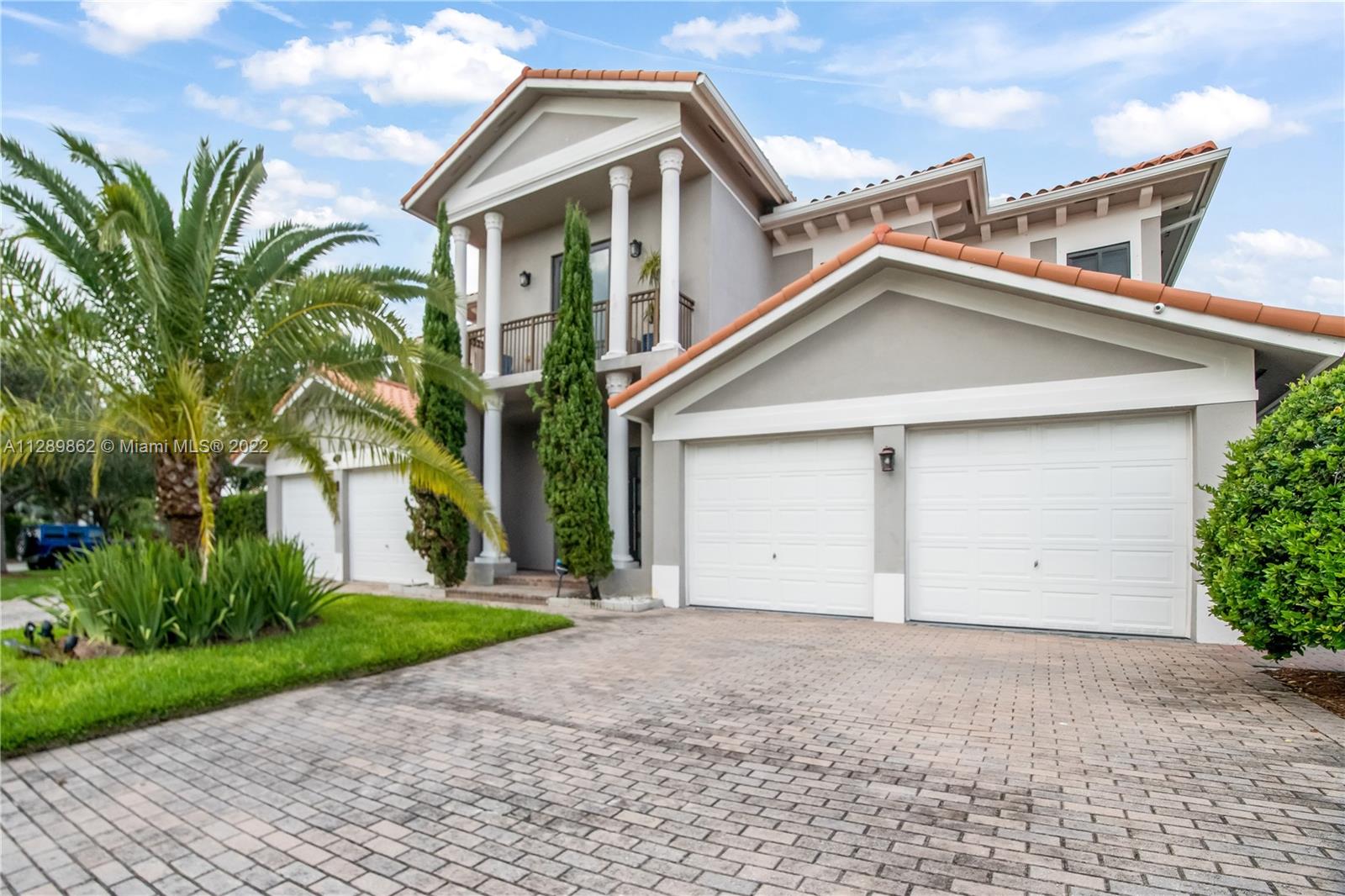 7783 Southwest 188th Street Cutler Bay, FL 33157 - Photo 1 of 70 a view of a white house next to a yard with potted plants