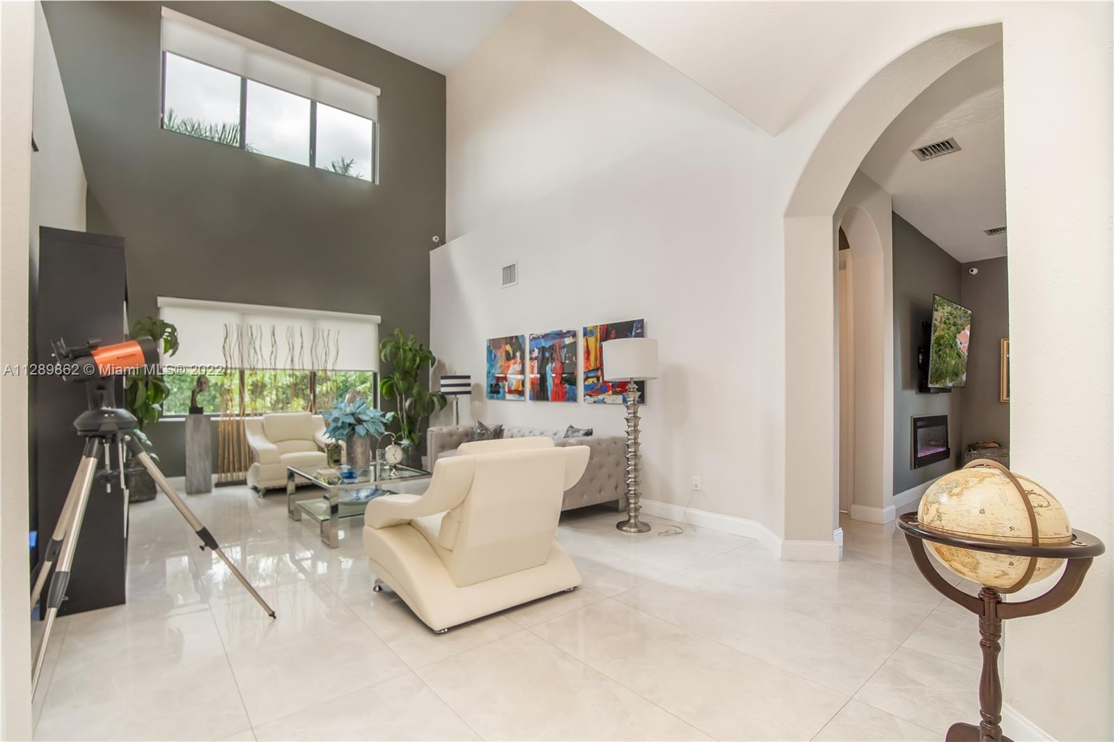 7783 Southwest 188th Street Cutler Bay, FL 33157 - Photo 13 of 70 a living room with furniture a chandelier and a mirror
