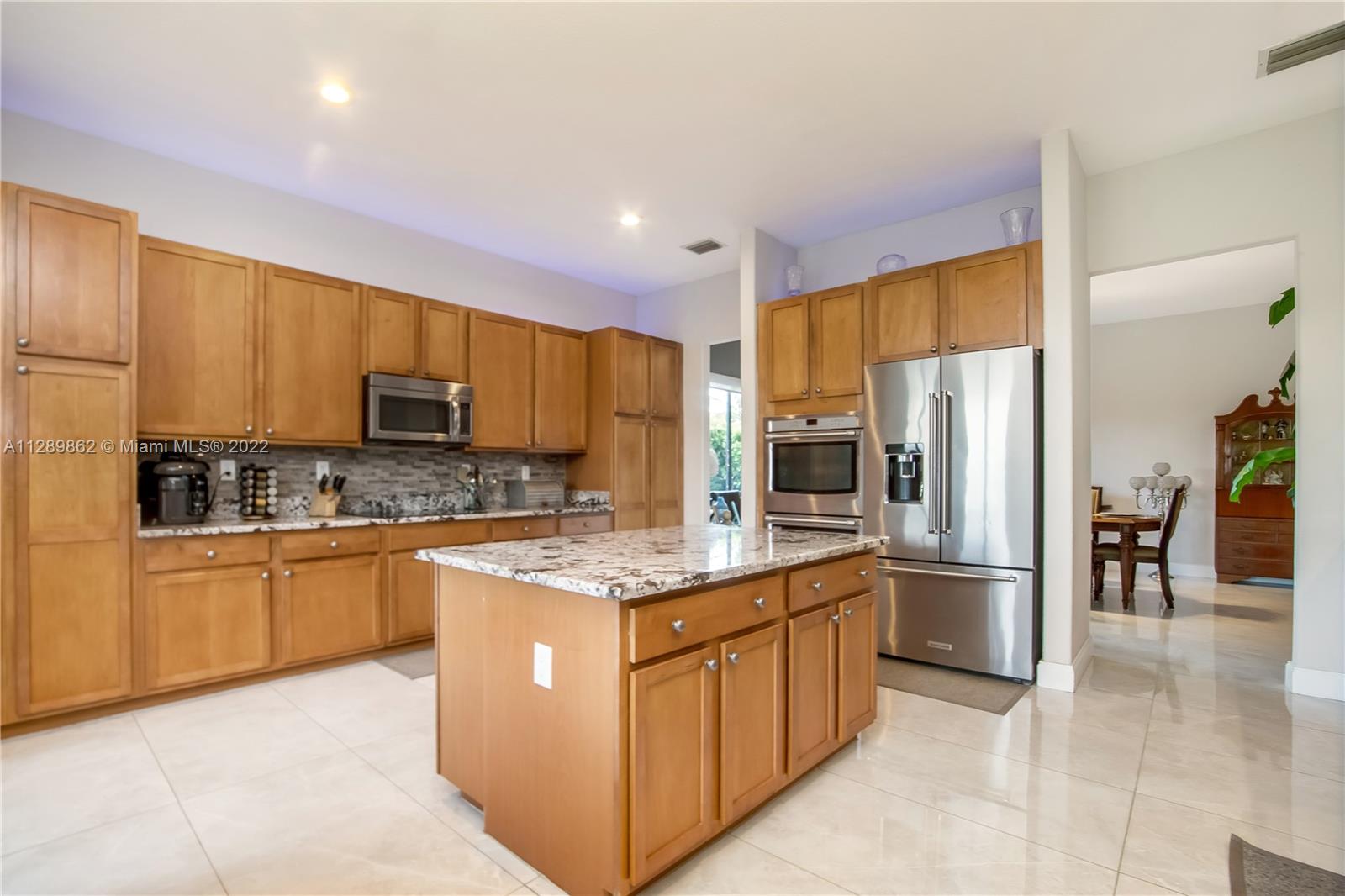7783 Southwest 188th Street Cutler Bay, FL 33157 - Photo 26 of 70 a kitchen with stainless steel appliances granite countertop a refrigerator a stove top oven a sink and dishwasher