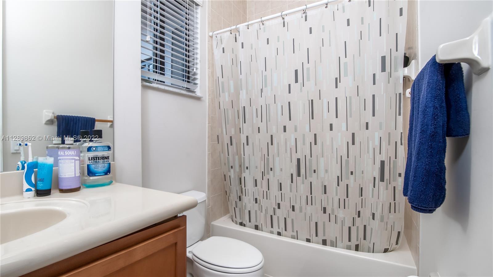 7783 Southwest 188th Street Cutler Bay, FL 33157 - Photo 50 of 70 a bathroom with a sink a toilet and shower curtain