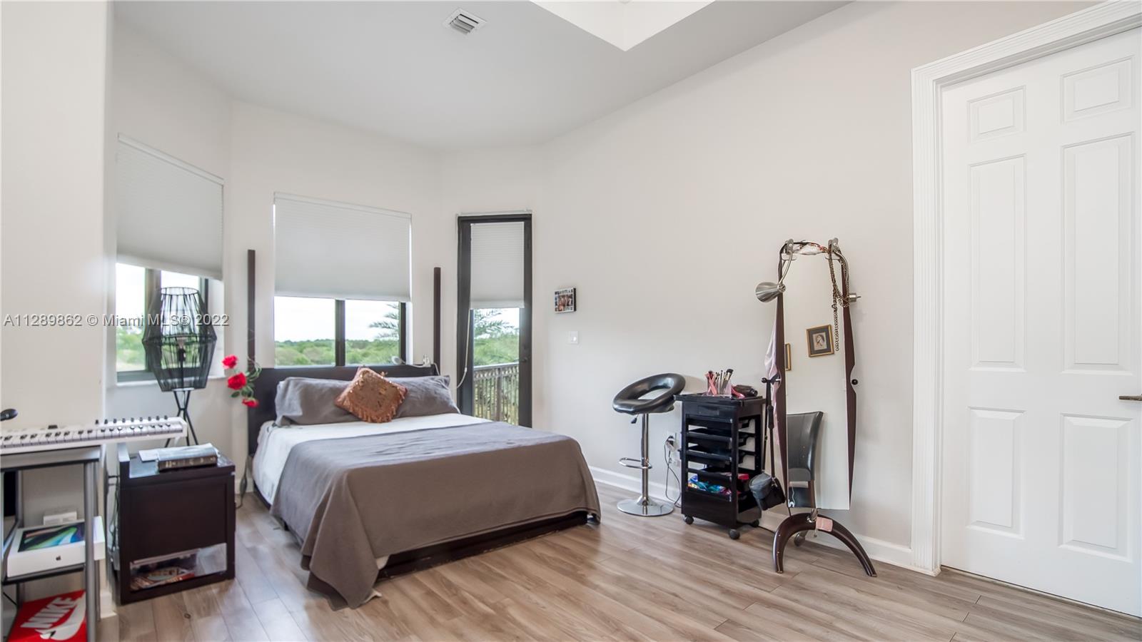 7783 Southwest 188th Street Cutler Bay, FL 33157 - Photo 53 of 70 a bedroom with a bed a large window and wooden floor