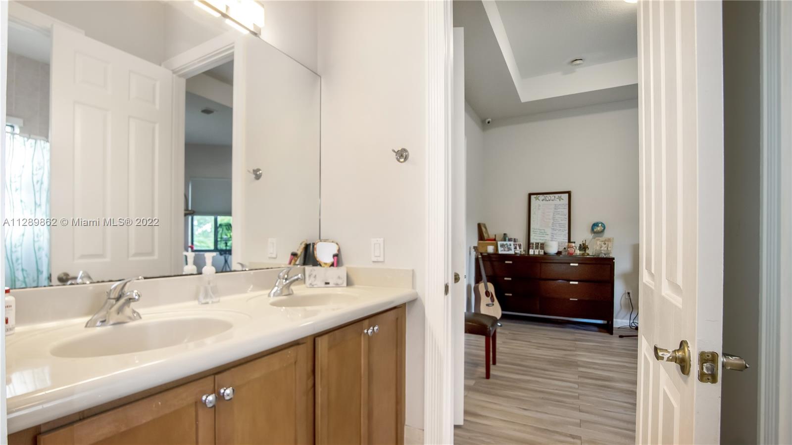7783 Southwest 188th Street Cutler Bay, FL 33157 - Photo 57 of 70 a en suite bathroom with a granite countertop sink and a mirror