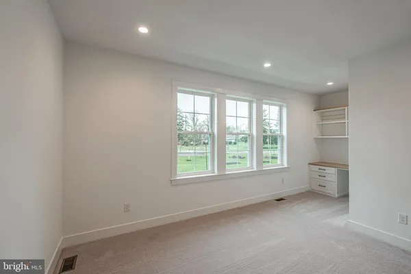 an empty room with windows and closet