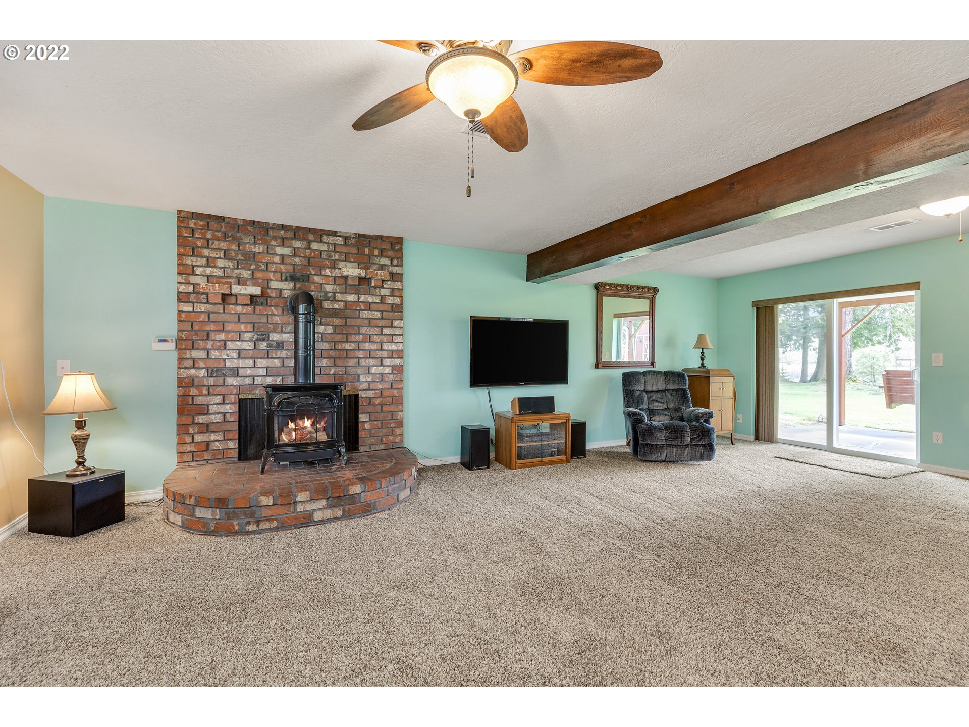 30026 Southeast Chase Road Gresham, OR 97080 - Photo 13 of 32 a living room with furniture a fireplace and a flat screen tv