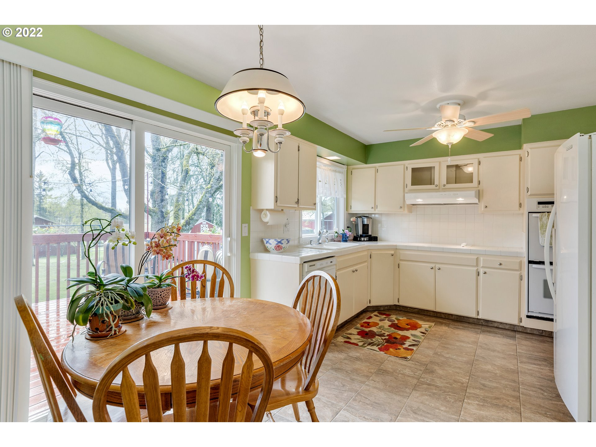 30026 Southeast Chase Road Gresham, OR 97080 - Photo 7 of 32 a kitchen with stainless steel appliances granite countertop a stove a refrigerator a sink a dining table and chairs with wooden floor