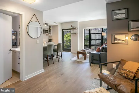 a living room with furniture a table and wooden floor
