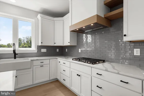 a kitchen with white cabinets stainless steel appliances and a window