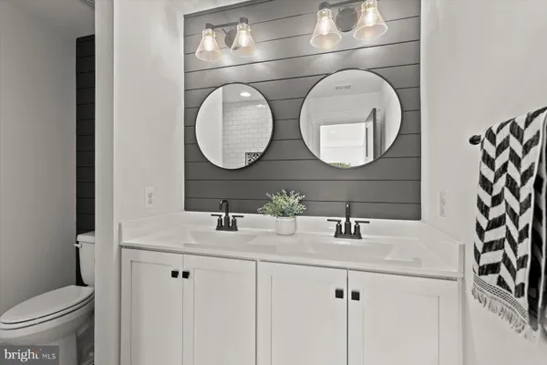 a front view of a house with a garden and trees