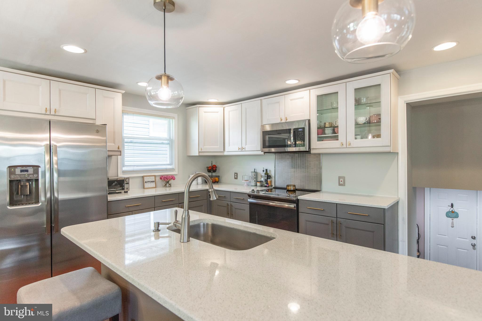 209 Glendale Road Havertown, PA 19083 - Photo 11 of 38 a kitchen with stainless steel appliances granite countertop a sink a stove a refrigerator cabinets and a dining table with wooden floor