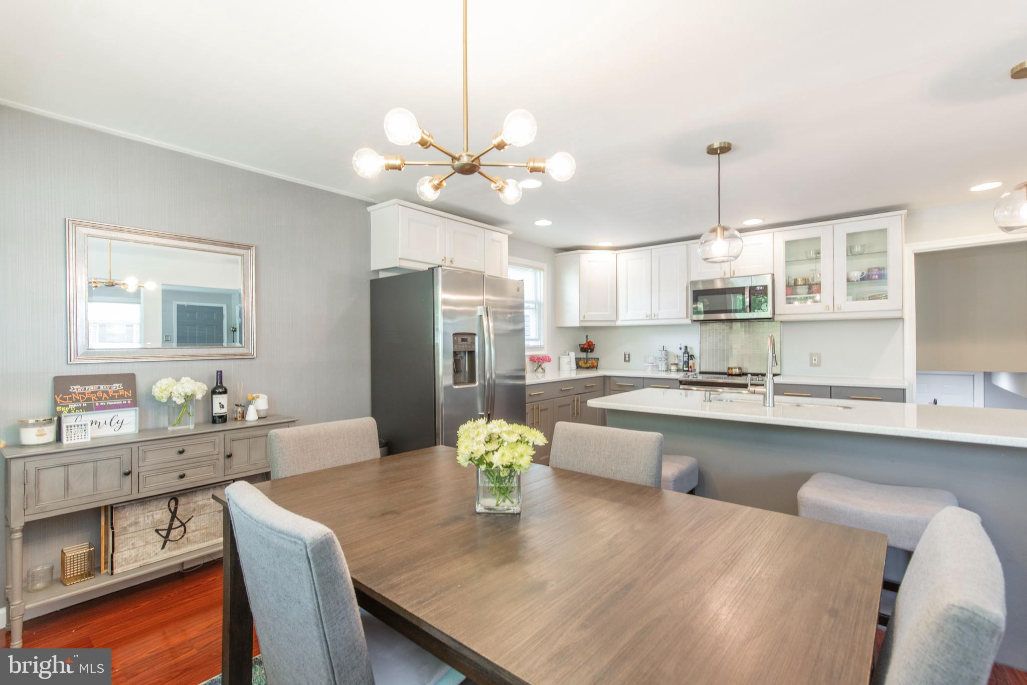 209 Glendale Road Havertown, PA 19083 - Photo 7 of 38 a kitchen with stainless steel appliances granite countertop a sink dishwasher a stove a dining table with chairs and white cabinets with wooden floor