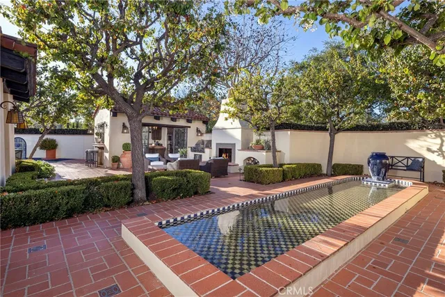 a view of a patio with couches table and chairs with wooden fence and plants