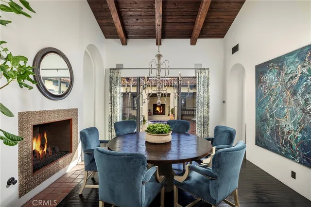 a dining room with furniture a fireplace and a chandelier