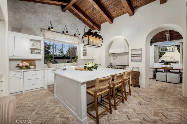 a kitchen with stainless steel appliances kitchen island granite countertop a table and chairs in it