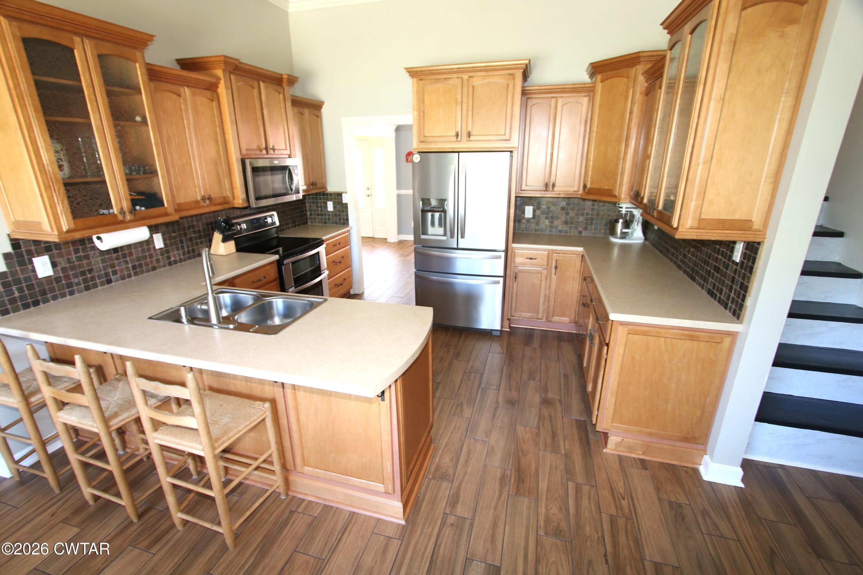 98 Browning Road Milan, TN 38358 - Photo 11 of 59 a kitchen with wooden floor sink stove and refrigerator