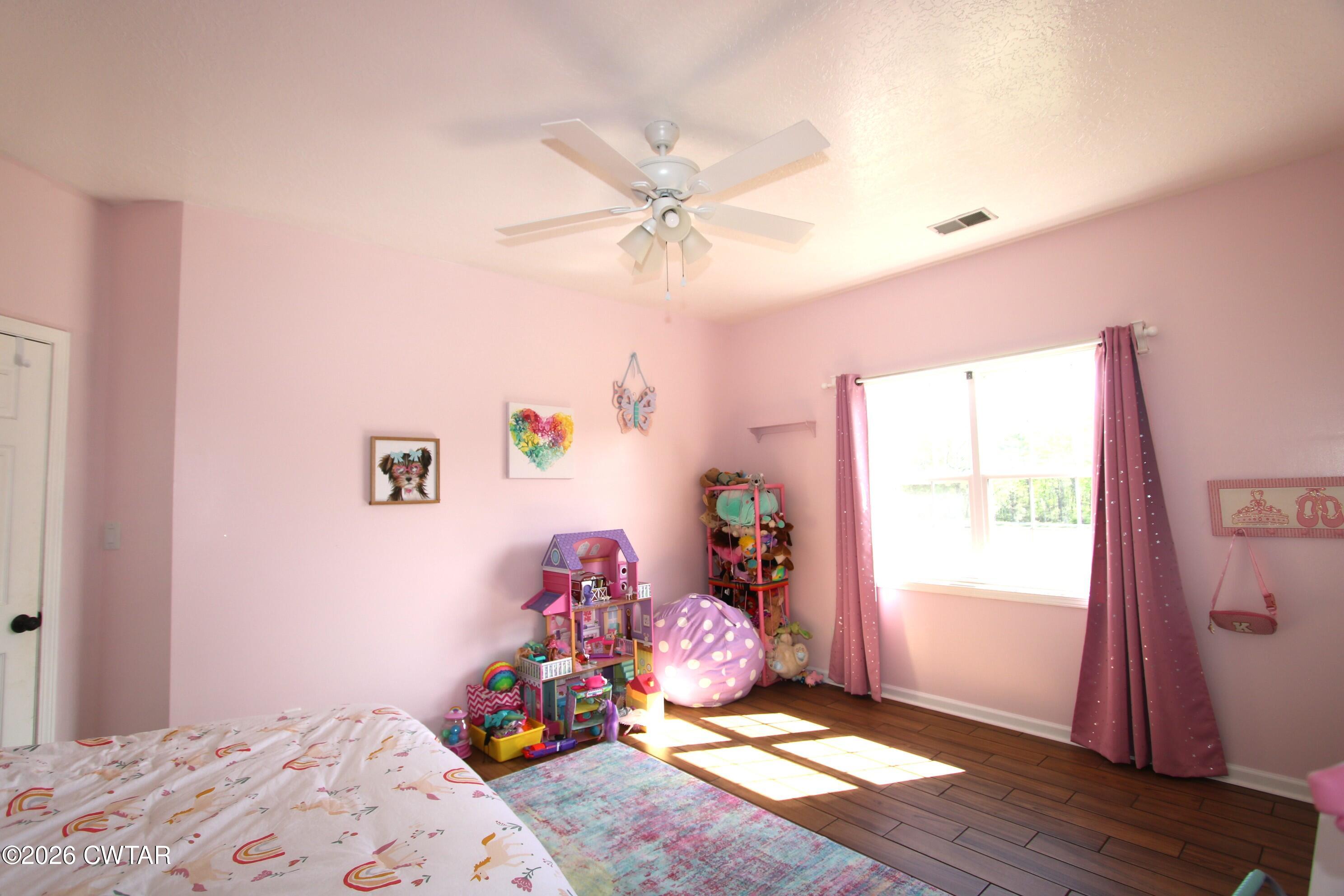 98 Browning Road Milan, TN 38358 - Photo 39 of 59 a bedroom with a bed and wooden floor