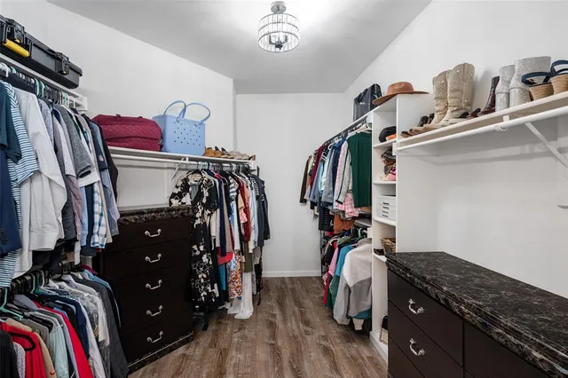 a view of walk in closet with clothes and shoes