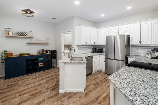 a kitchen with a refrigerator sink and cabinets