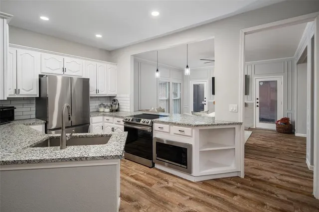 a kitchen with stainless steel appliances granite countertop a sink stove and refrigerator