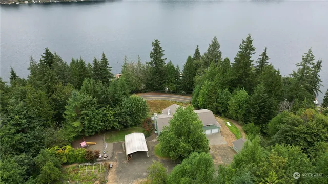 an aerial view of a house with a yard and lake view