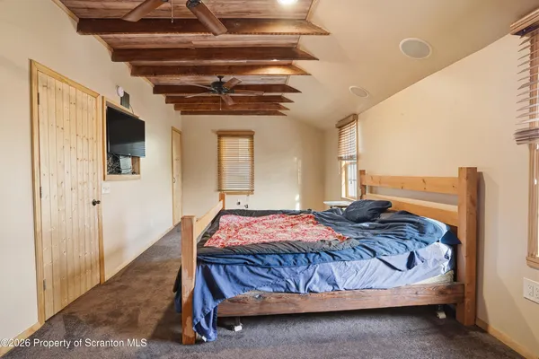 a bedroom with a bed window and flat screen tv