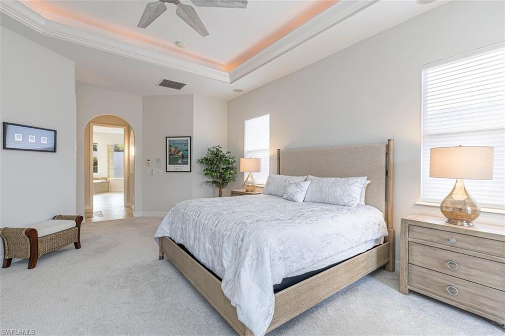 7984 Tiger Lily Drive Naples, FL 34113 - Photo 18 of 45 a bedroom with a bed and a chandelier