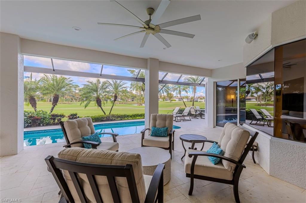 7984 Tiger Lily Drive Naples, FL 34113 - Photo 30 of 45 a dining room with furniture a flat screen tv and a floor to ceiling window