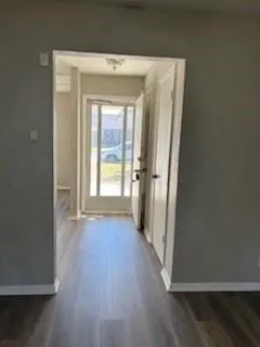 an empty room with wooden floor and a window