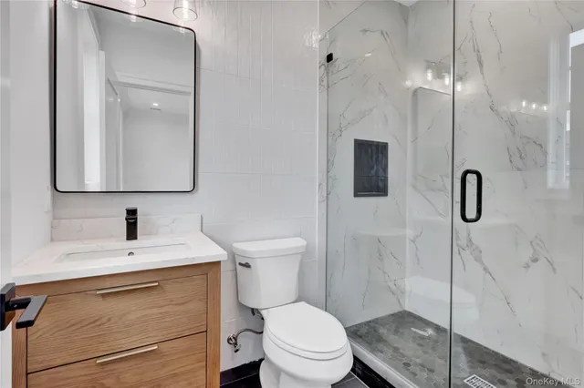 a bathroom with a toilet sink vanity and mirror
