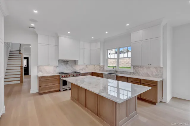 a large kitchen with kitchen island a sink stainless steel appliances and cabinets