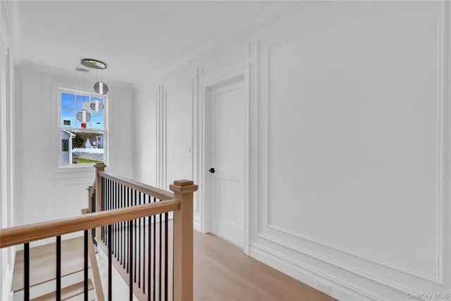 a view of a hallway with wooden floor and entryway