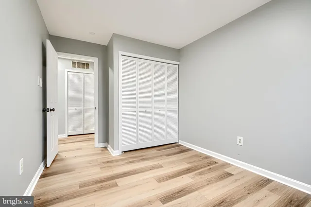 an empty room with wooden floor and closet