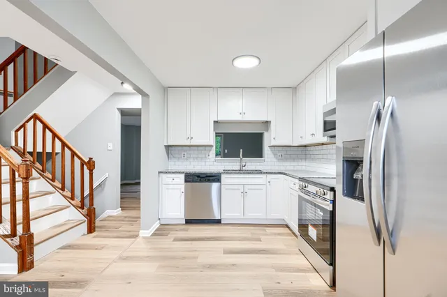 a kitchen with white cabinets and stainless steel appliances