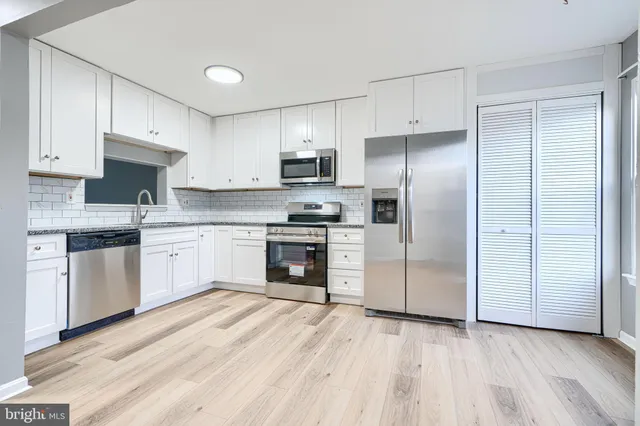 a kitchen with a refrigerator sink and cabinets