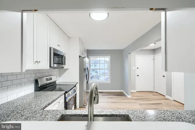 a kitchen with stainless steel appliances granite countertop a sink stove and cabinets