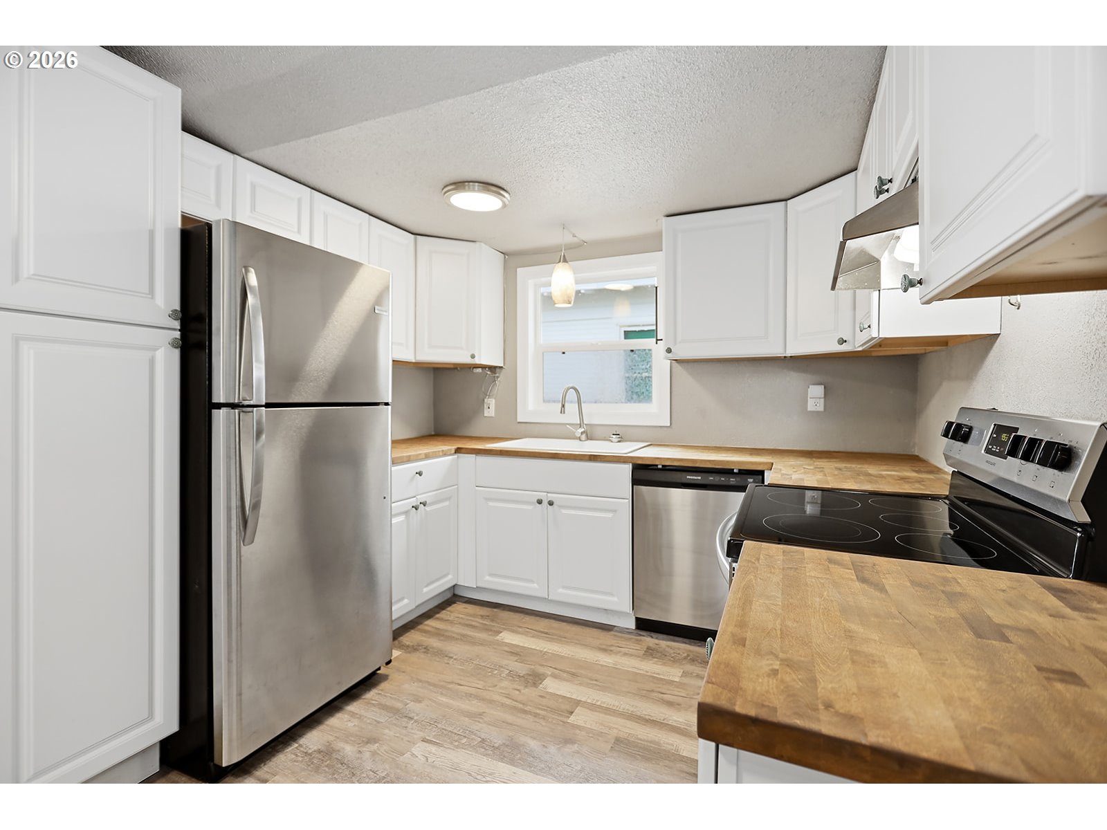 417 East Court Street Goldendale, WA 98620 - Photo 15 of 38 a kitchen with a refrigerator stove and white cabinets
