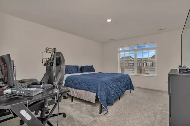 a bedroom with a bed and large windows