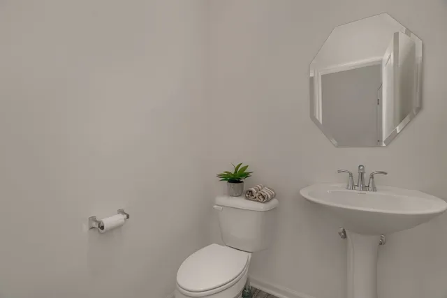 a white toilet sitting next to a bathroom sink