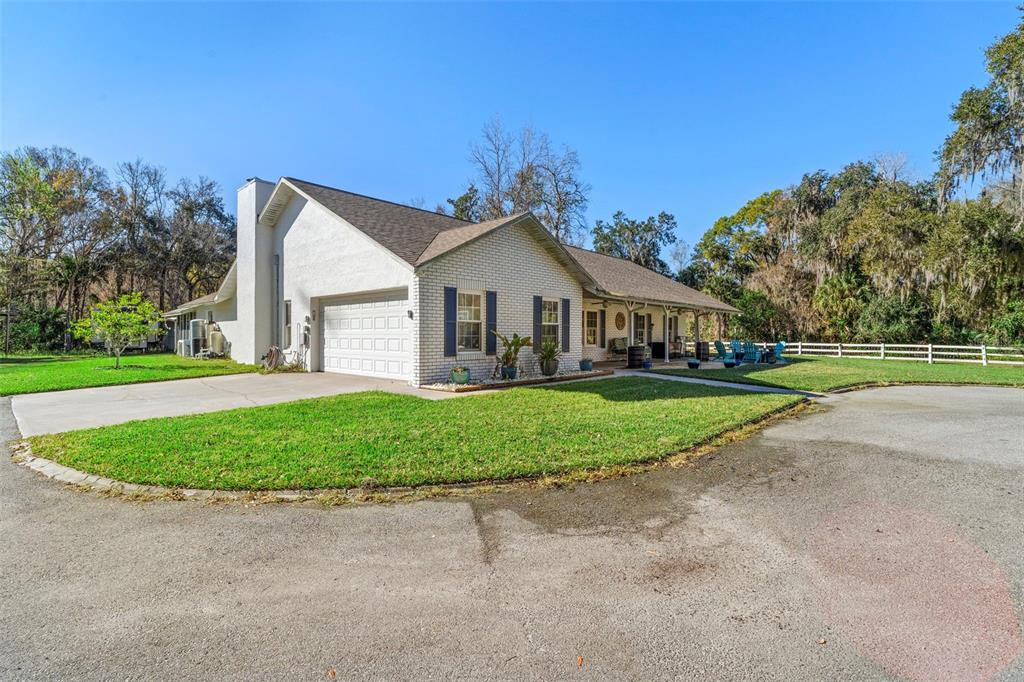 3080 Ragis Road Edgewater, FL 32132 - Photo 4 of 86 a front view of a house with a garden and yard